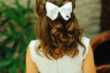 side braids coming on top the head and waves down plus a white bow are a gorgeous combo for a wedding