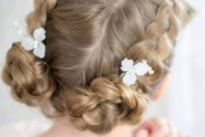 side braids covering the head and with top knots, with fabric blooms for a super cute and lovely flwoer girl look