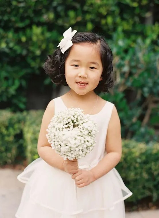 waves down, side parting and a white bow on one side are all your flower girl needs to look fantastic