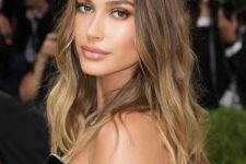 Hailey Bieber wearing long light brown hair with an ombre effect and waves looks gorgeous