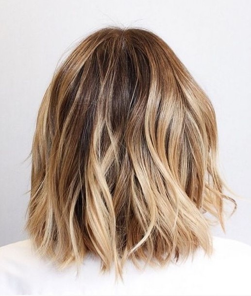 a beautiful and a bit messy long bronde bob with golden and bleached blonde balayage and a darker root is chic