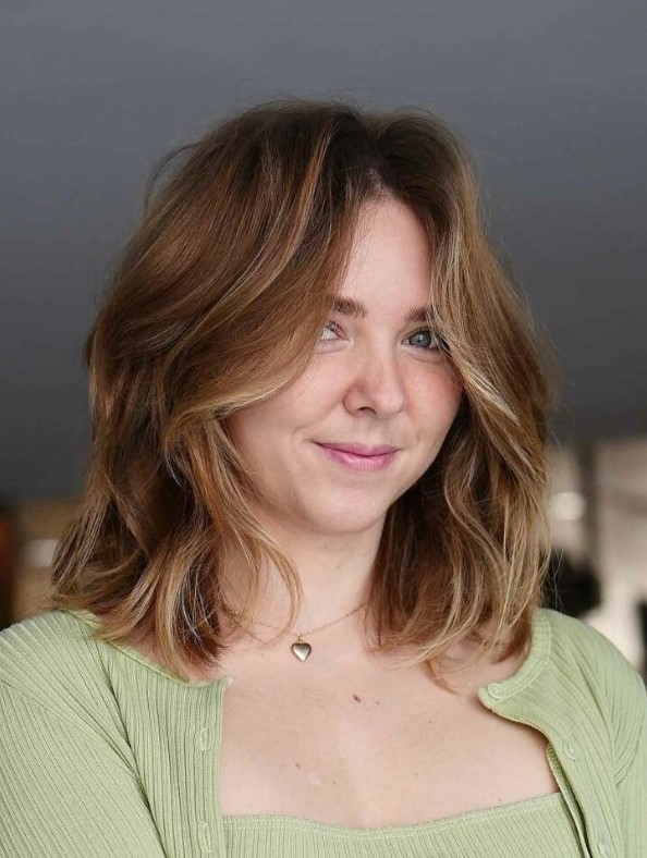 a beautiful and soft brown lob with blonde highlights and a lot of volume plus curtain bangs is a beautiful idea