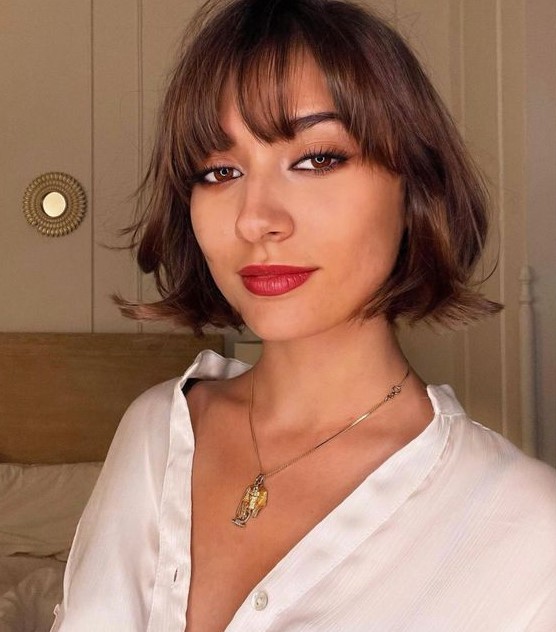 A beautiful brunette chin length bob with wispy bangs and waves is a stylish and eye catching idea