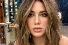 a beautiful long layered bob with blonde highlights and messy waves is a lovely solution that isn’t too bold but is soft and chic