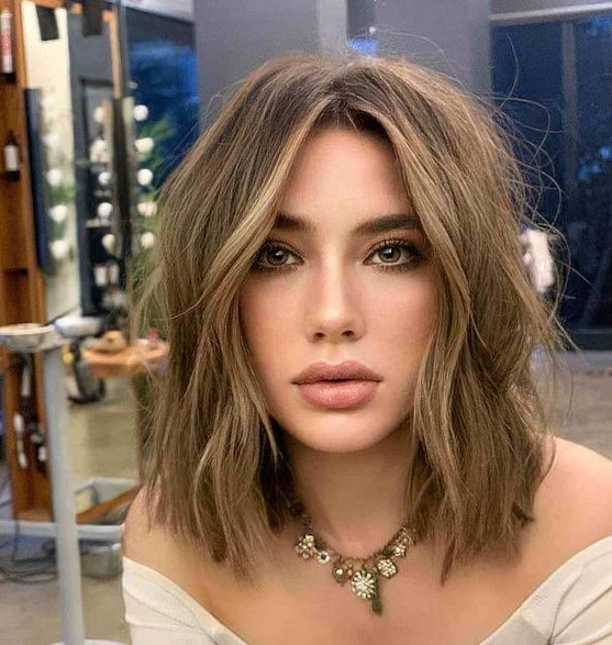 a beautiful long layered bob with blonde highlights and messy waves is a lovely solution that isn't too bold but is soft and chic