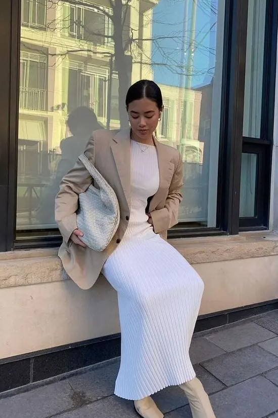a beautiful neutral spring outfit with a pleated mxi dress, a tan oversized blazer, tan booties and a creamy woven tote