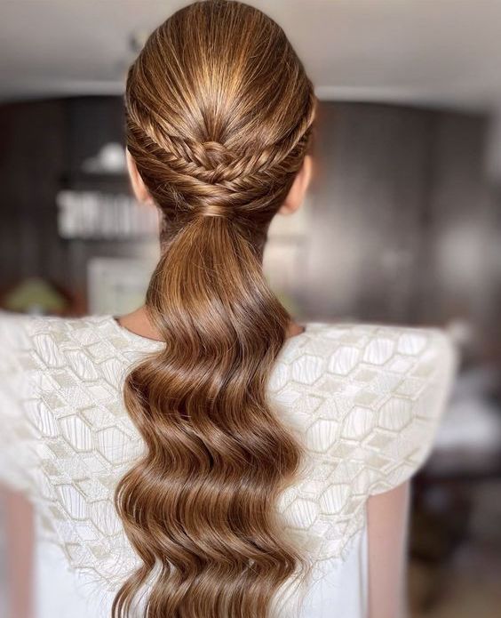 a beautiful wavy low ponytail with a braided halo and a bump on top is a cool and chic solution