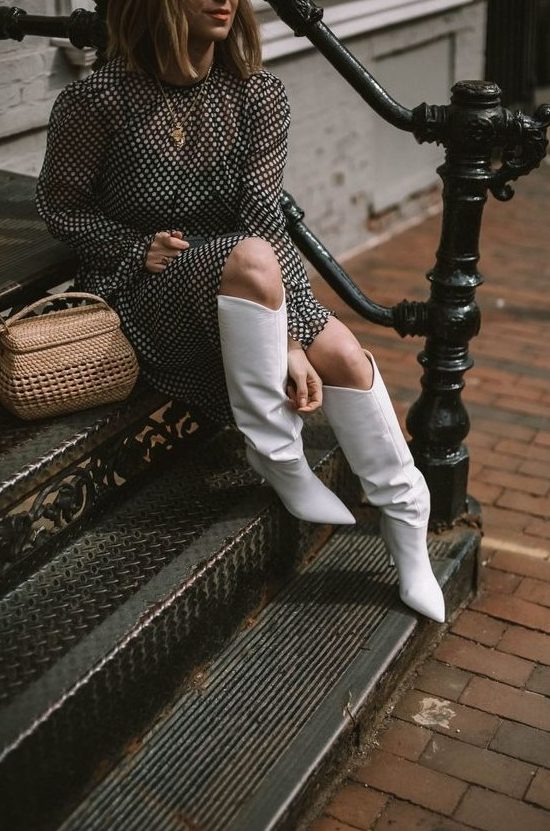 a black and white polka dot midi dress with long sleeves, white slouchy boots and a basket-style bag
