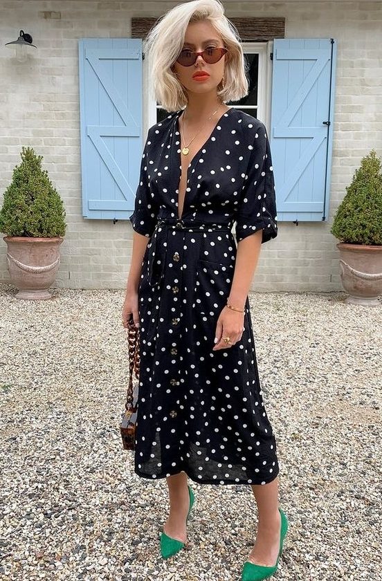a black polka dot midi dress with a plunging neckline, a chic bag with chain and bold green shoes are a nice idea for a summer date
