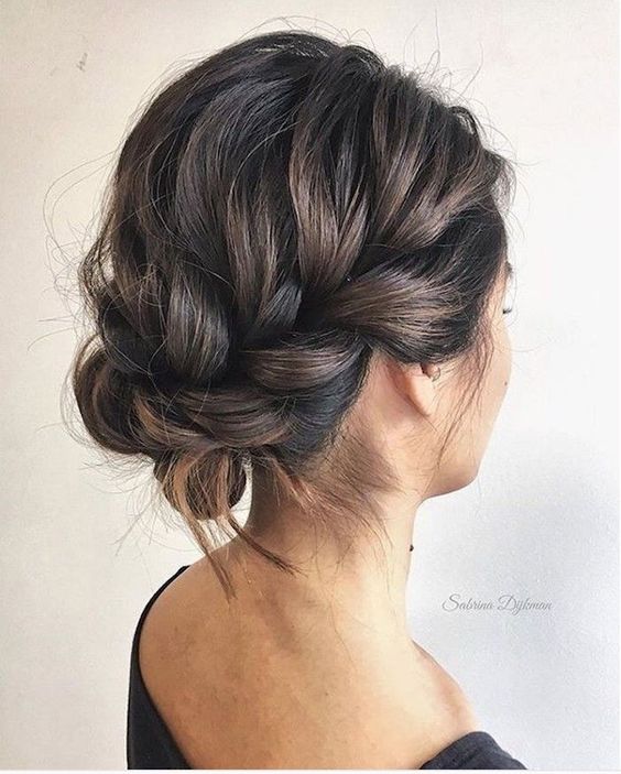 a braided updo with a loose halo and a bump on top is a cool and catchy idea for a holiday party