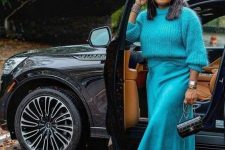 a bright look with a turquoise jumper, a slip midi skirt, snakeskin print boots and a black bag