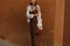 a brown polka dot slip dress, a white cardigan, strappy mules and a small brown bag for a chic look