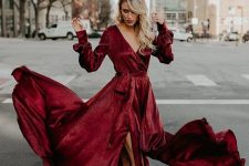 a burgundy wrap maxi dress with a deep neckline, long sleeves and a slit, blakc ankle strap heels for a fall or winter wedding