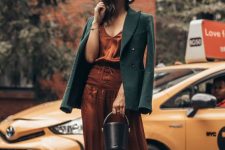 a burnt ornage midi slip dress with lacing up, black shoes, a green blazer and a black bucket bag are a cool combo