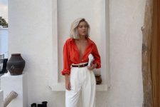 a casual summer wedding guest look with an orange shirt, white pants, black shoes, a brown belt and a white bag