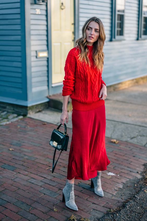 a casual winter wedding guest look with a red sweater, a red slip midi skirt, grey suede boots and a black bag