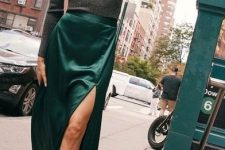 a catchy and cool wedding guest look with a grey long sleeve top, an emerald midi skirt with a slit, black embellished lace up shoes