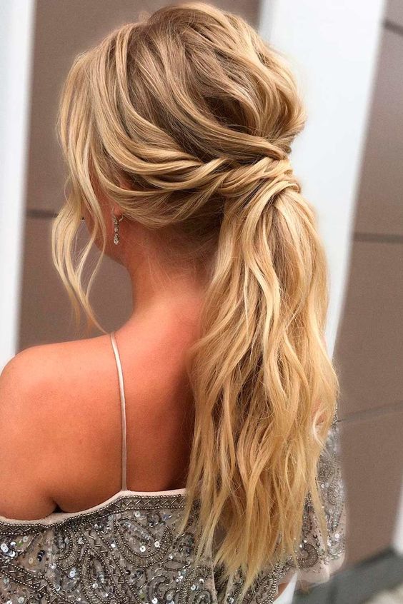 A catchy modern low ponytail with a messy and wavy top, messy hair down and face framing hair is cool