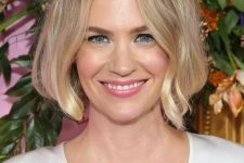 a chin-length blonde bob with a darker root and messy parting, with waves is a stylish idea, it looks gentle and chic
