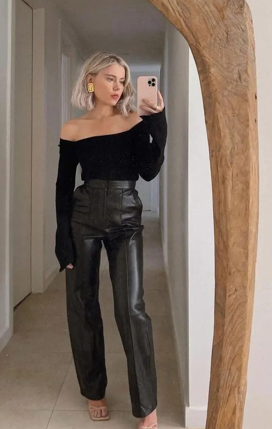 a classy guest outfit with a black off the shoulder top, black leather pants, strappy shoes and statement earrings