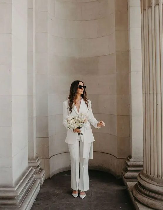 A classy white pantsuit with flare pants and white shoes is great for any wedding related party or a wedding