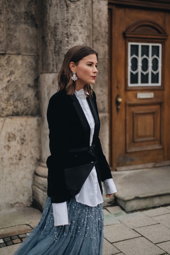 a creative winter wedding guest look with a grey embellished skirt, a white shirt, a black velvet blazer and statement earrings
