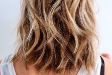 a dreamy beach hairstyle with medium-length bronde hair, blonde hihglights and waves is perfect for summer