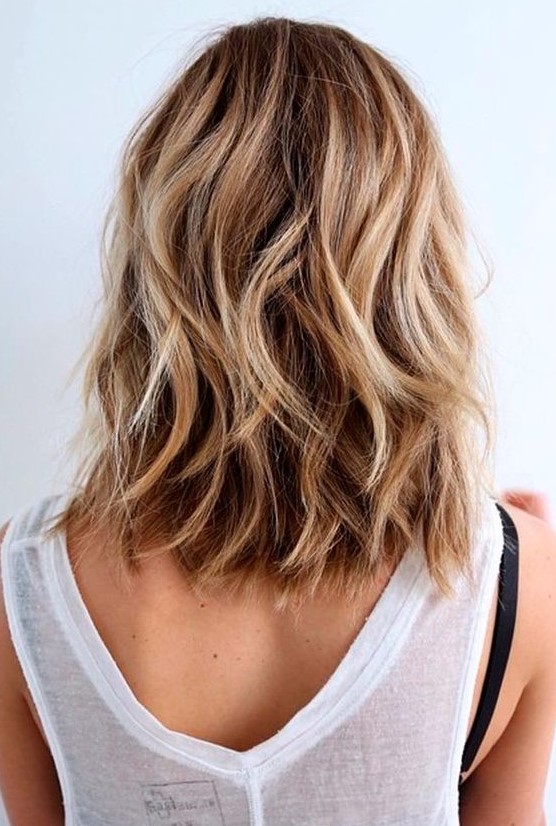 A dreamy beach hairstyle with medium length bronde hair, blonde hihglights and waves is perfect for summer