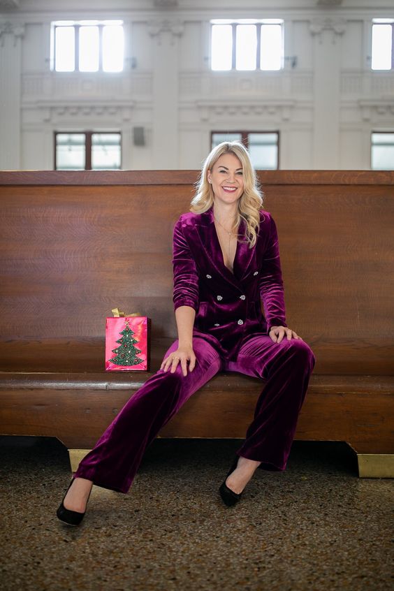 a fantastic winter wedding guest outfit with a purple velvet pantsuit, black shoes and a lariat necklace