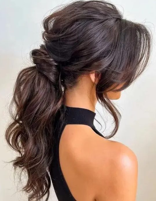 A jaw dropping wavy messy low ponytail with a messy volume on top, locks framing the face is amazing for a glam look