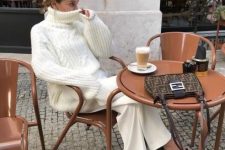 a lovely and refiend outfit with a white chunky patterned oversized sweater, matching trousers, black strappy shoes and a printed bag