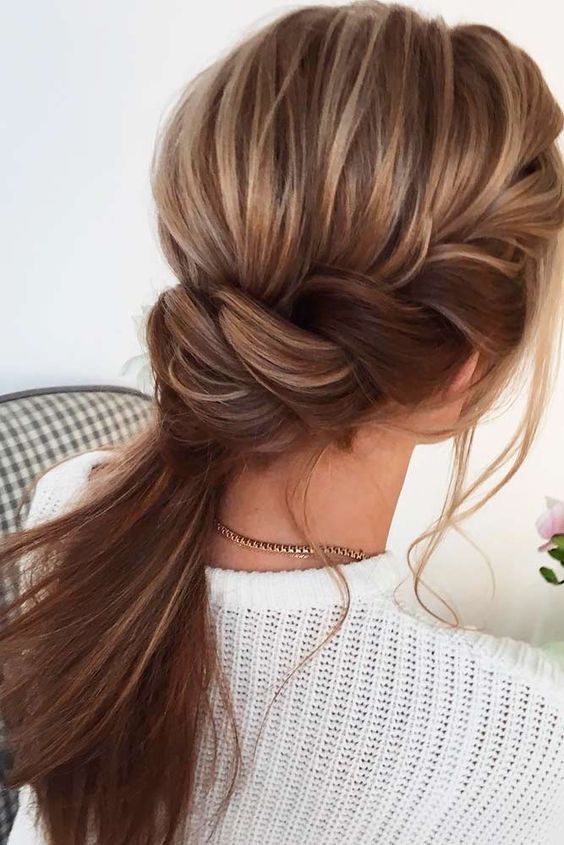 a low ponytail with a side braid and a bump on top is a cool and casual party hairstyle for the holidays