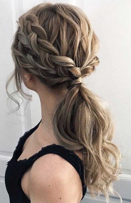 A low wavy ponytail with a double braided halo and face framing locks is amazing