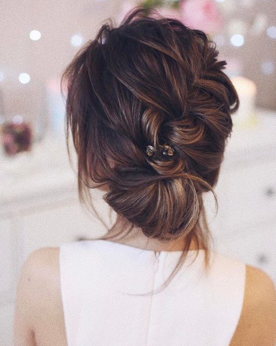 a messy diagonal braid updo with bangs and a rhinestone hair pin will be a catchy and cool hairstyle for the holidays