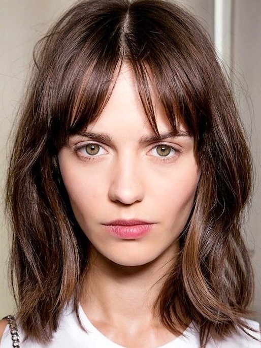 A messy layered brown shoulder length bob with highlights and bottleneck bangs is a lovely idea to wear right now