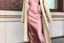 a pink slip midi dress, white shoes and a tan trenchcoat for a lovely and effortless chic look