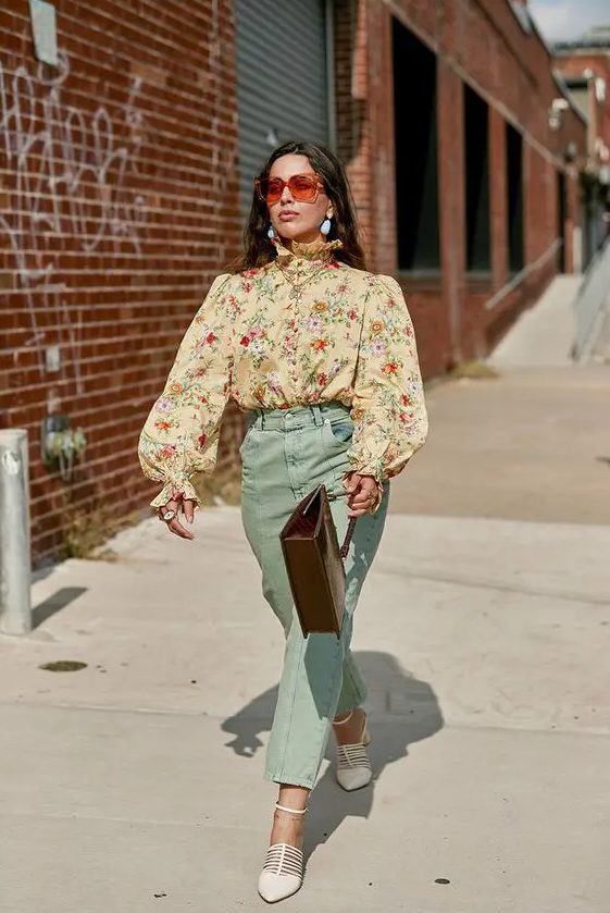 A pretty and elegant vintage inspired wedding guest look with a tan floral blouse with puff sleeves, mint colored pants, white shoes and a brown bag