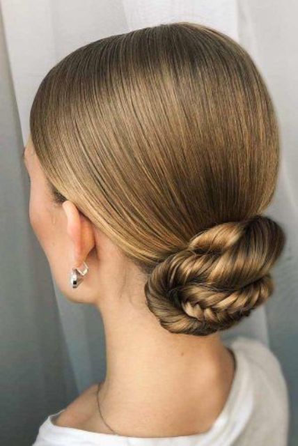 a sleek top plus a fishtail braid low bun is a cool and chic solution for a modern bridal shower look