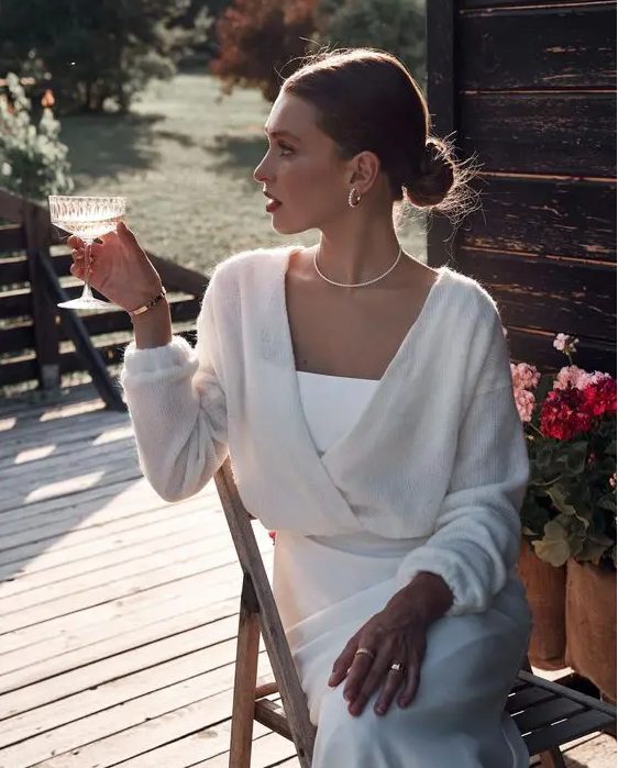 A slip white dress paired with a semi sheer white cropped cardigan, some chic jewelry are great for a bride to be