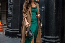 a stylish winter wedding guest look with a green midi dress, nude shoes, a brown midi coat and a black bag