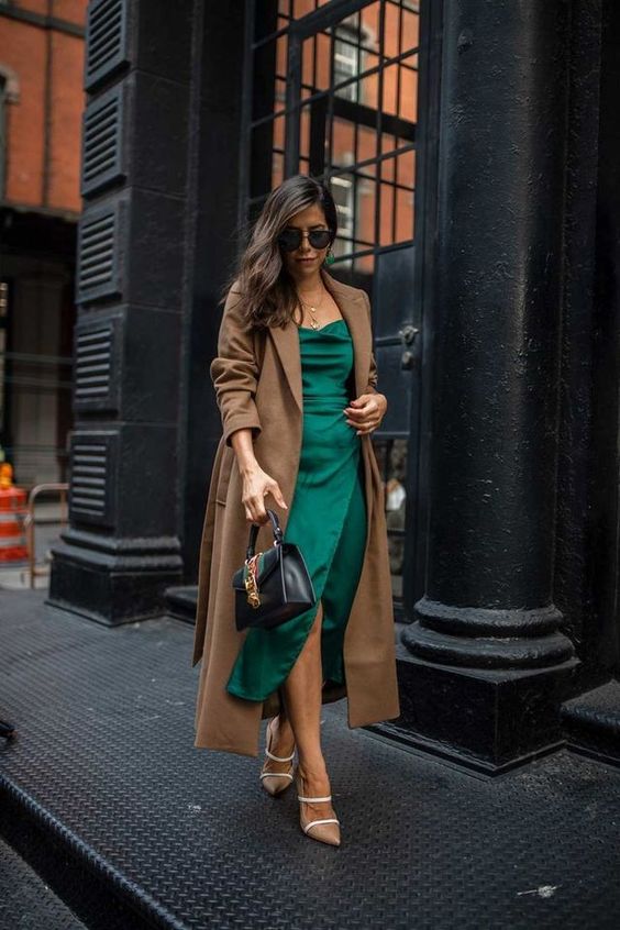 a stylish winter wedding guest look with a green midi dress, nude shoes, a brown midi coat and a black bag