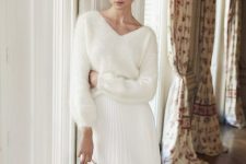 a white fuzzy sweater with a V-neckline, a knee pleated skirt, dusty blue shoes with bows for a winter bridal shower