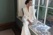 a white pantsuit, white shoes and statement earrings plus a beaded bag are a great combo for a bridal shower