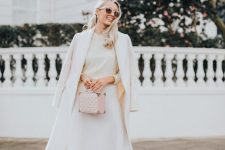 a white sweater, a midi skirt with an asymmetrical rim, white shoes, a white coat and a pink box bag