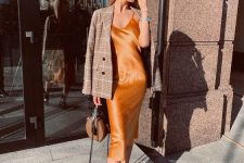 an orange slip midi dress, black boots, a plaid blazer and a brown bag for a refined fall outfit