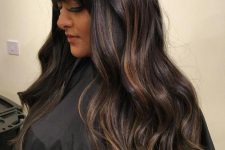 beautiful long dark brown hair with copper and caramel balayage, witha classic fringe and waves is a cool solution