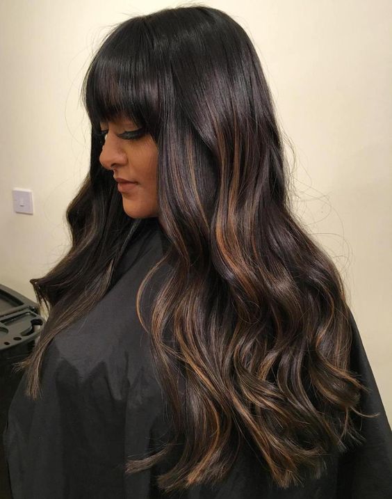 beautiful long dark brown hair with copper and caramel balayage, witha classic fringe and waves is a cool solution