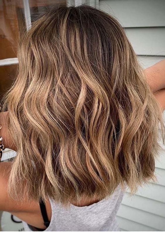 Brown medium length hair with blonde highlights and waves is a stylish and relaxed idea for anyone