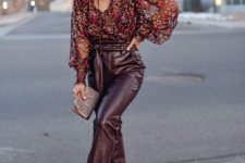 burgundy leather pants, a moody floral blouse, a small grey bag and blush shoes are a cool solution for a fall wedding guest
