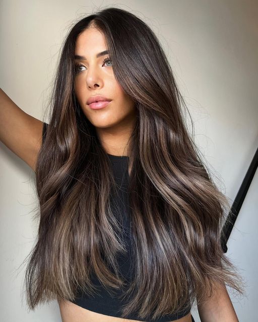 extra long and volumetric dark brown hair with caramel balayage and a delicate wave is a fantastic idea with a lot of dimension